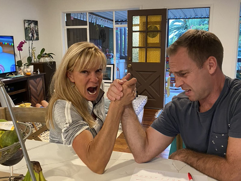 Dawn Matze Playfully Arm Wrestles Man, both of them with wild facial expressions